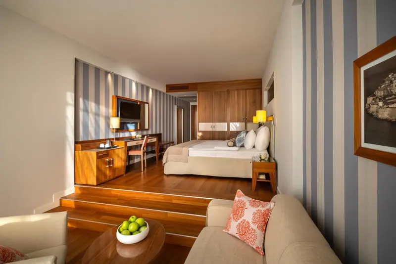 Une chambre lumineuse avec un lit double et un coin salon.