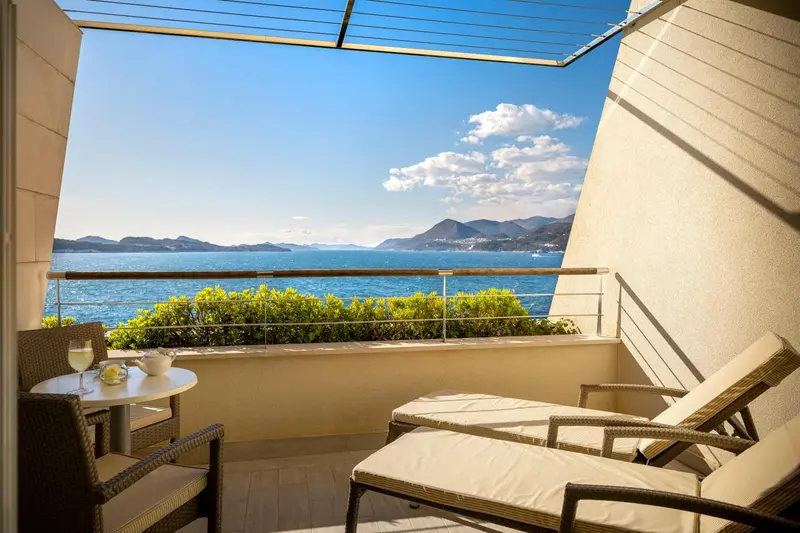 Vue sur la mer depuis une terrasse avec mobilier de jardin.