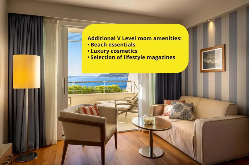 Un salon de chambre d'hôtel avec vue sur la mer et un coin lecture.