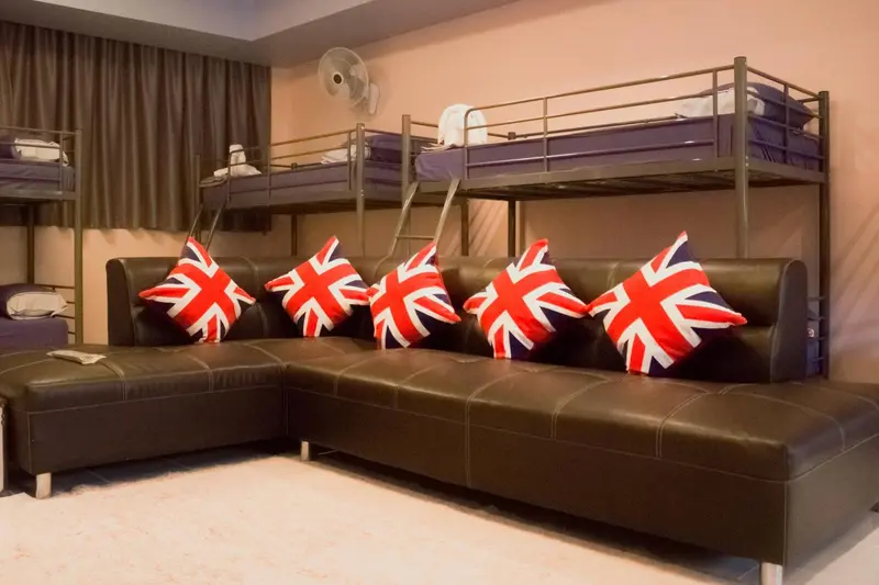 Espace de détente avec canapé d'angle et lits superposés.