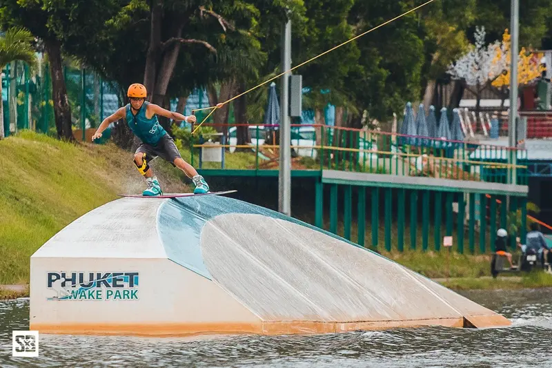 Une personne pratique le wakeboard sur un plan d'eau artificiel.