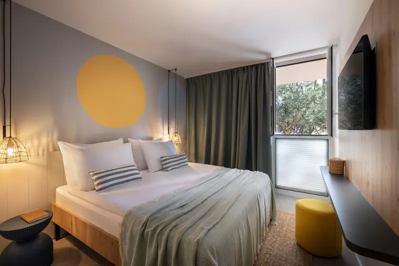 Une chambre moderne avec un grand lit et une décoration sobre.