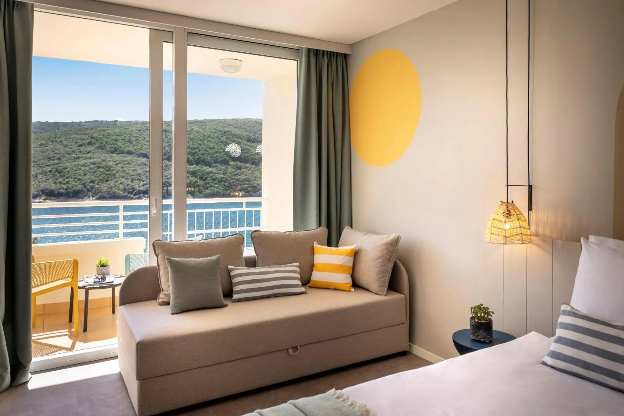 Espace de détente lumineux avec canapé et vue sur la mer.