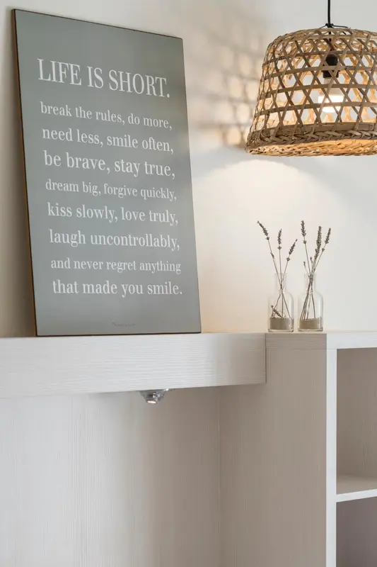 Une décoration murale avec un message inspirant au-dessus d'une étagère.