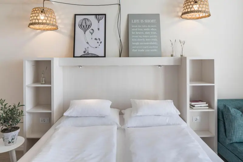 Une chambre lumineuse avec un lit double et une décoration murale.