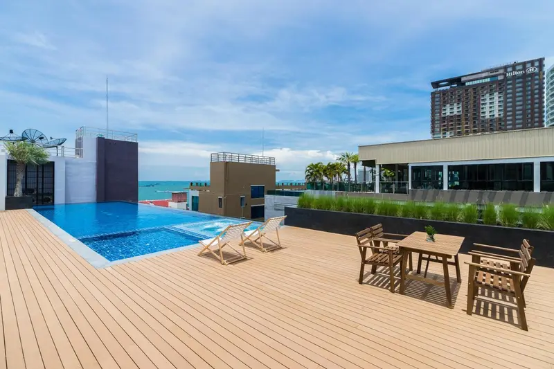 Terrasse avec piscine et mobilier de détente.