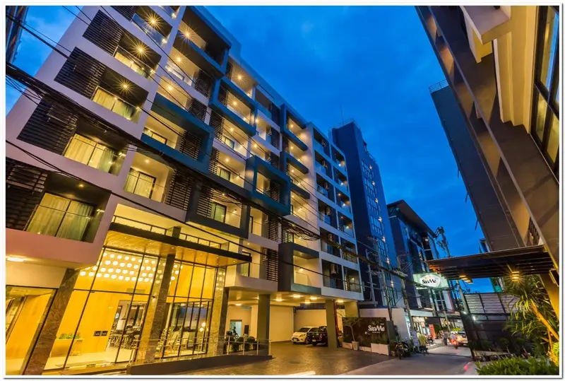 Façade moderne d'un bâtiment avec un éclairage chaleureux et une entrée accueillante.