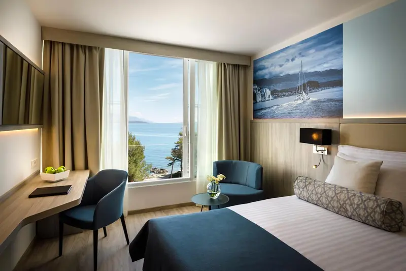 Une chambre lumineuse avec vue sur la mer et un coin salon.