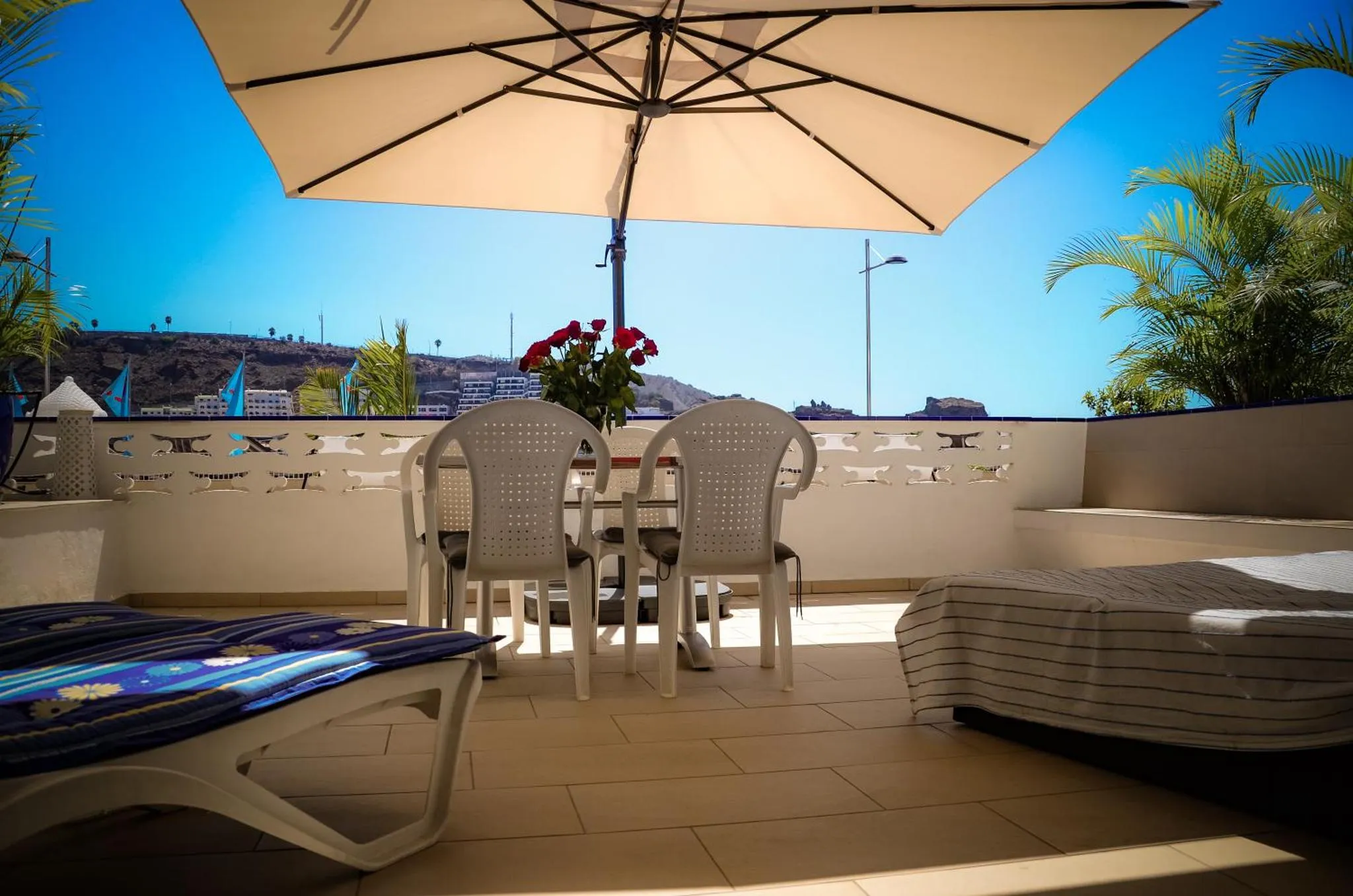 Terrasse aménagée avec mobilier de jardin et vue sur la mer.