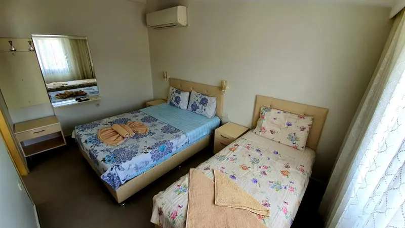 Une chambre avec deux lits et un miroir.