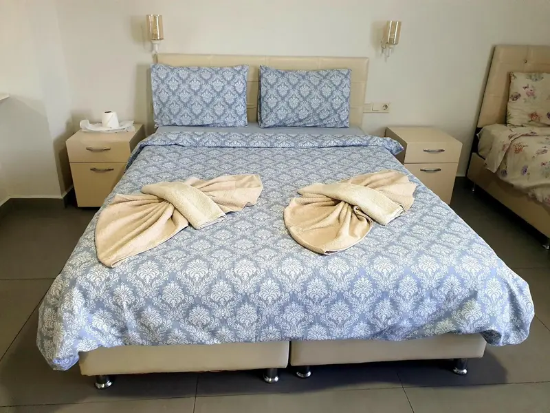 Une chambre d'hôtel avec un grand lit recouvert d'une courtepointe à motifs.