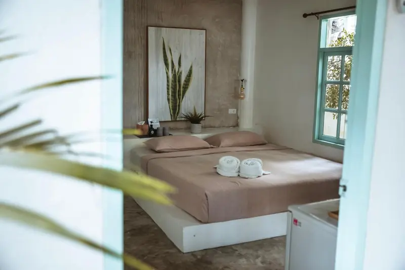 Une chambre lumineuse avec un lit double et une décoration sobre.