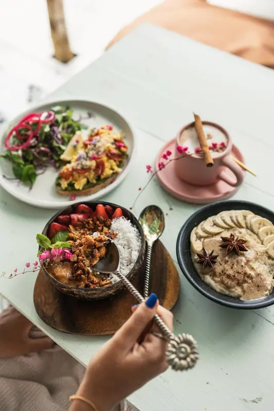 Assiettes colorées de plats variés sur une table claire.