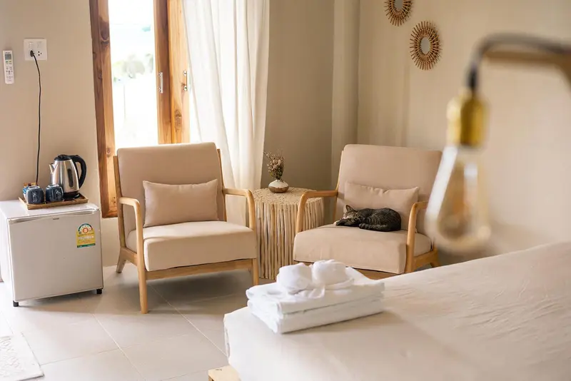 Un coin salon clair avec deux fauteuils et une table d'appoint.