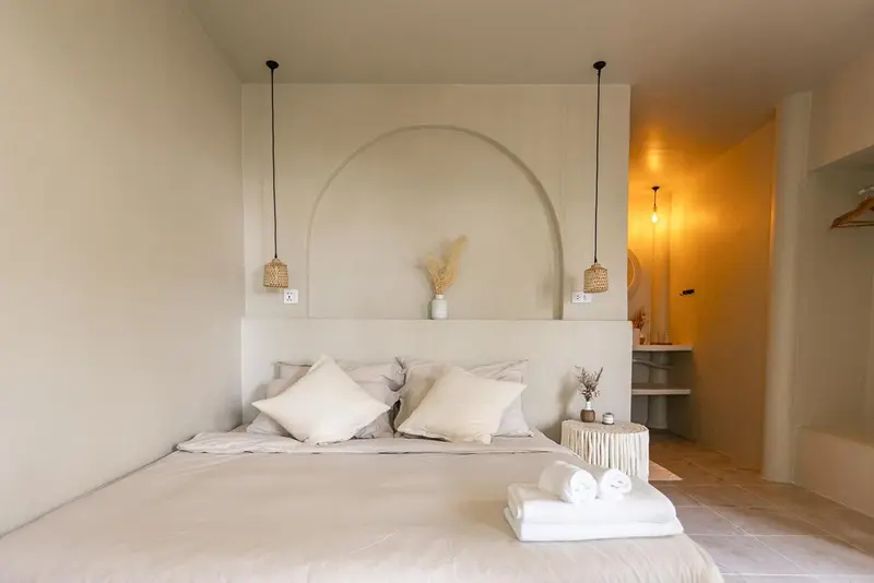 Une chambre lumineuse avec un grand lit et une décoration minimaliste.