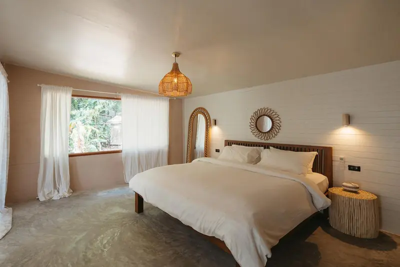 Une chambre lumineuse avec un grand lit recouvert de draps blancs.