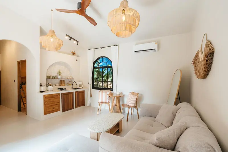 Interieur clair avec canape, table basse et kitchenette.