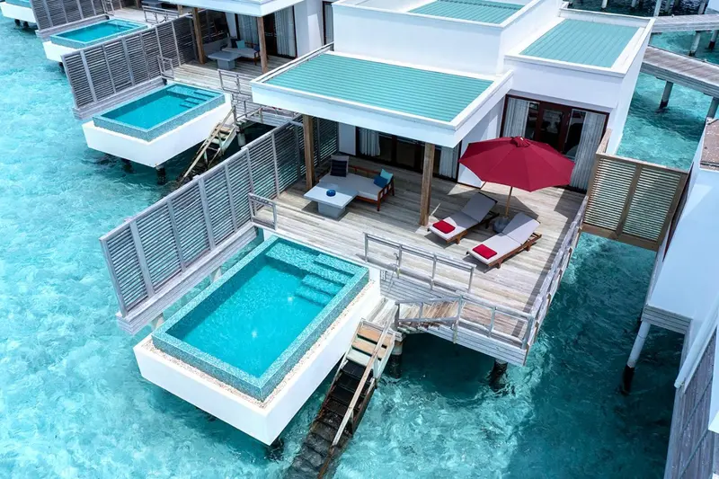 Terrasses de villas sur pilotis avec piscine privée et mobilier d'extérieur.