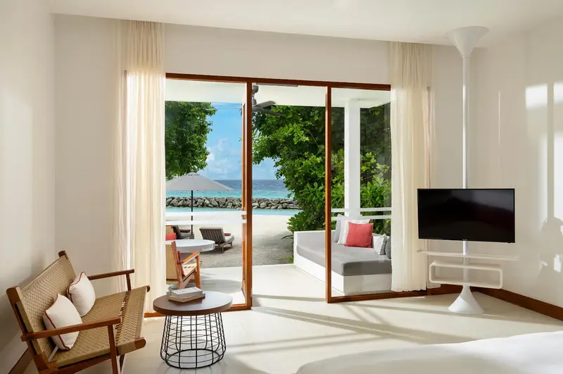 Espace de détente lumineux avec vue sur une plage tropicale.