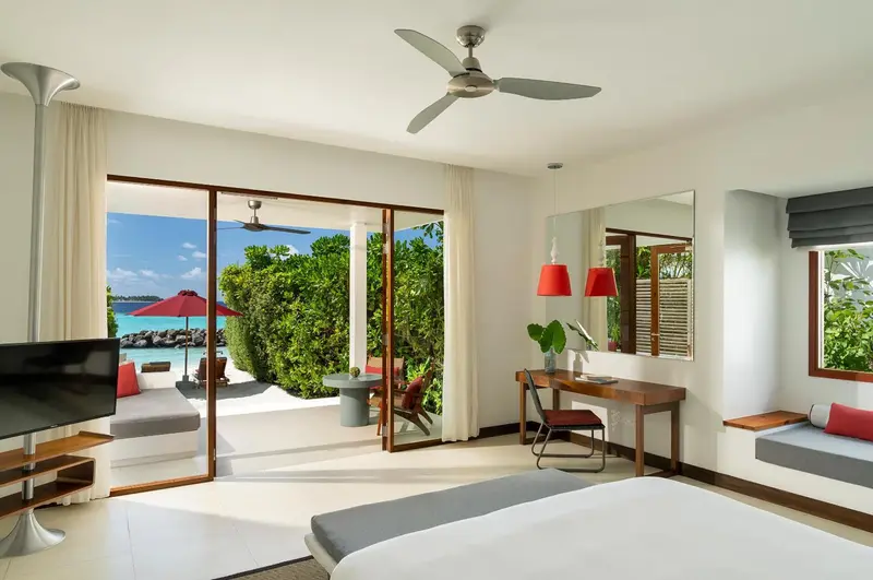 Une chambre lumineuse s'ouvre sur une terrasse avec vue sur la mer.