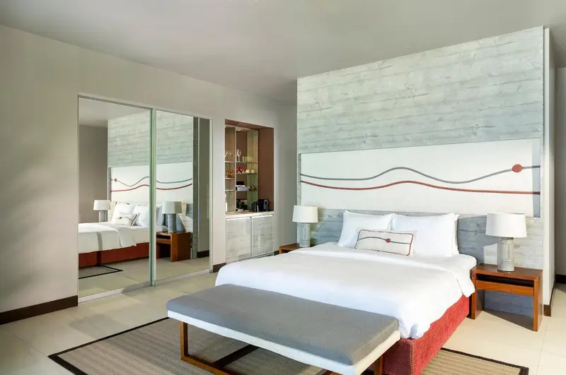 Une chambre lumineuse avec un grand lit et des miroirs.