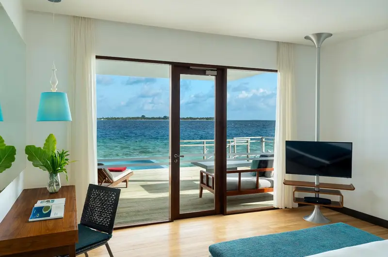 Une chambre lumineuse s'ouvre sur une terrasse avec vue sur l'océan.