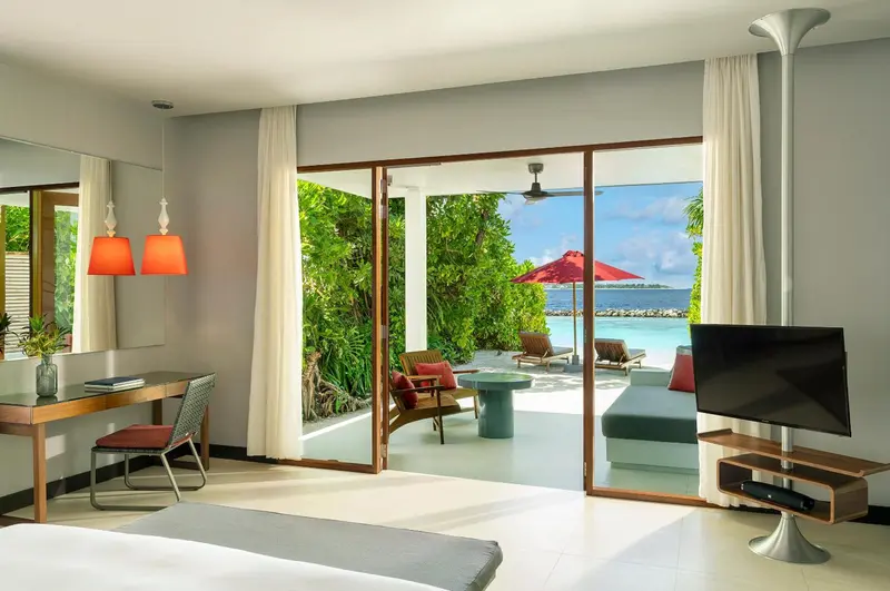Une chambre lumineuse s'ouvre sur une terrasse avec vue sur la mer.