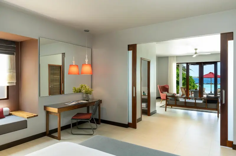 Espace de vie lumineux avec bureau et accès à une terrasse vue sur mer.