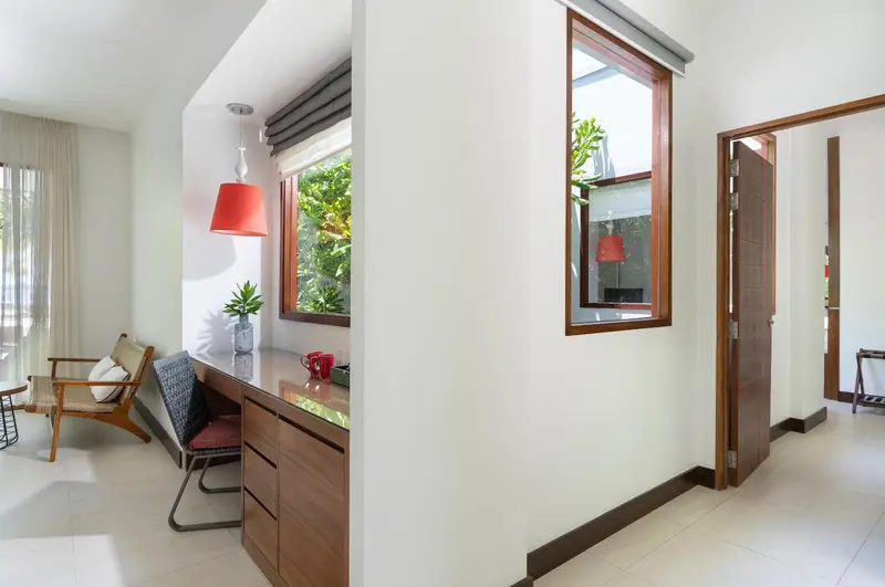 Espace bureau lumineux avec chaise et fenêtre donnant sur la végétation.