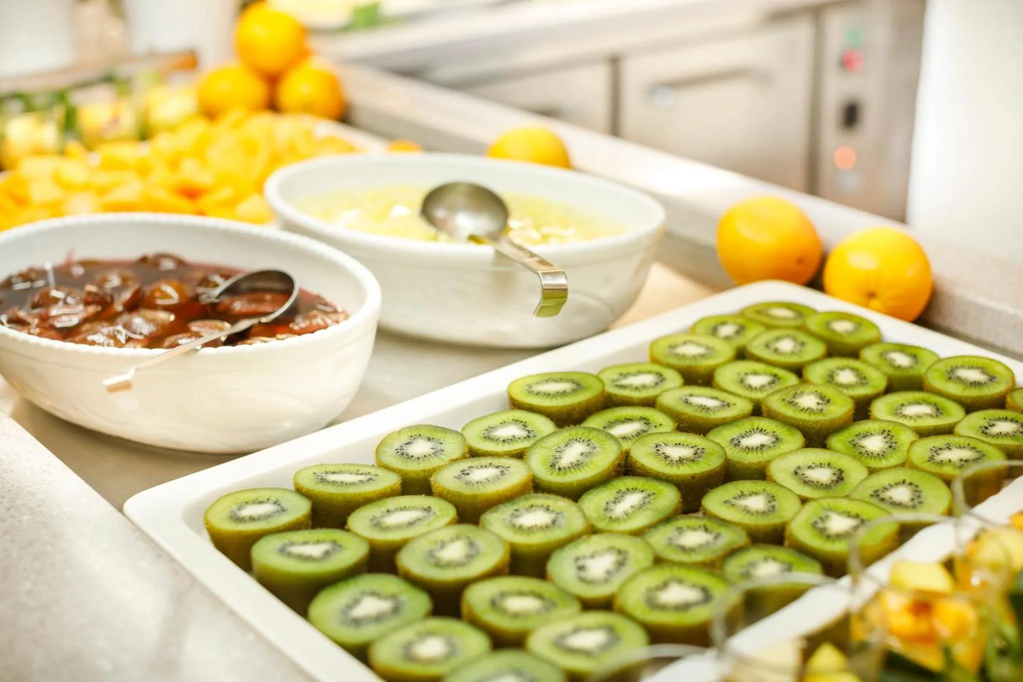 Un buffet propose des fruits frais coupés en morceaux.