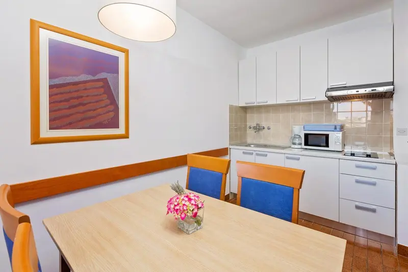 Une salle à manger lumineuse avec une kitchenette équipée.