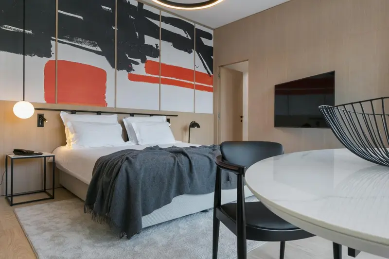 Une chambre moderne avec un grand lit et un coin repas.