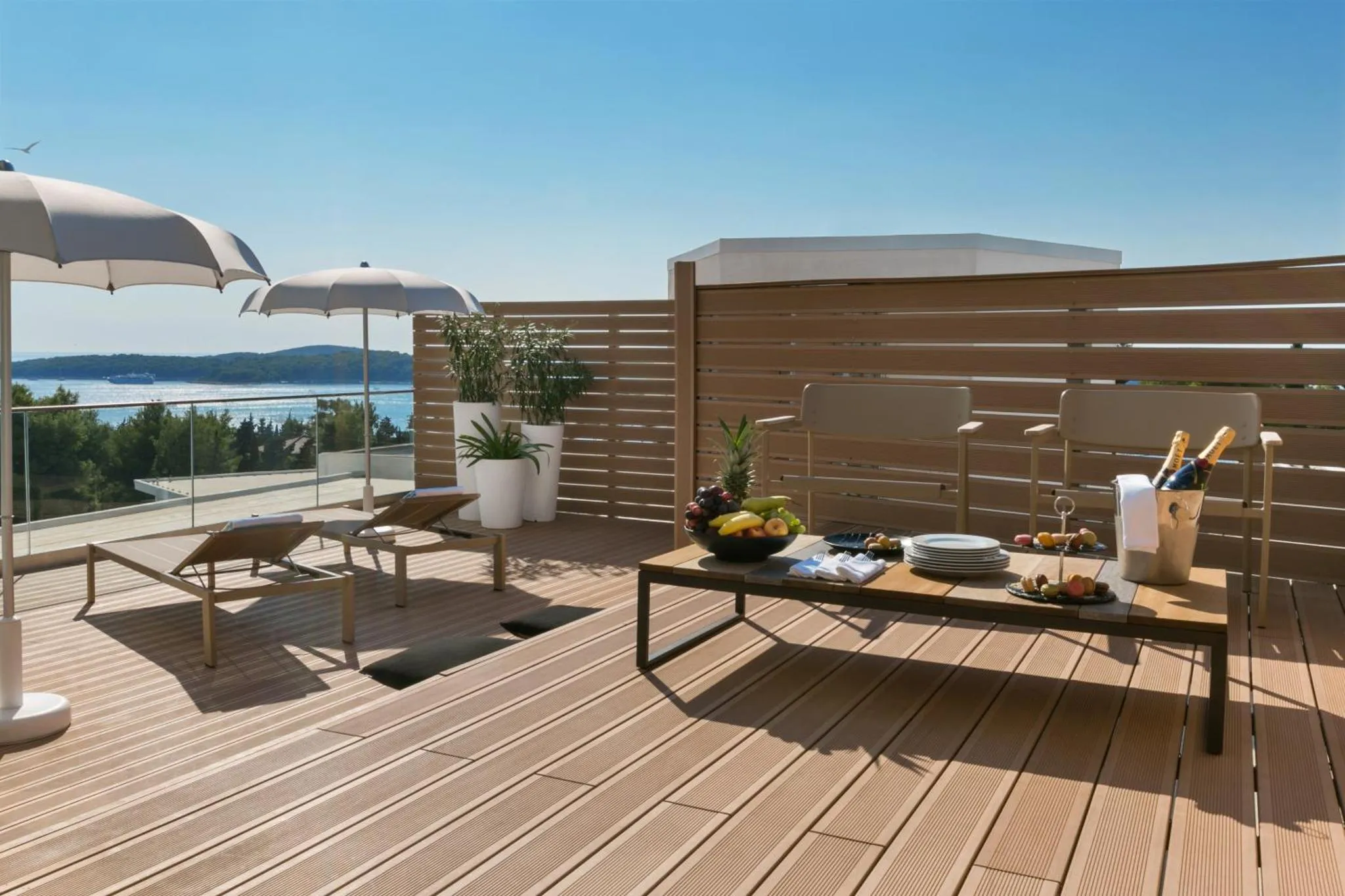 Terrasse aménagée avec transats, table basse et vue sur la mer.