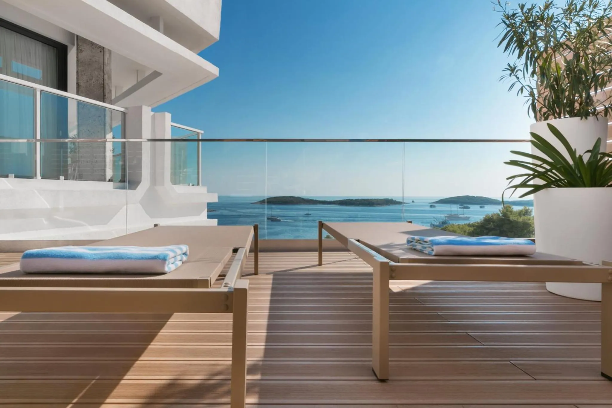 Transats sur une terrasse en bois avec vue sur la mer.