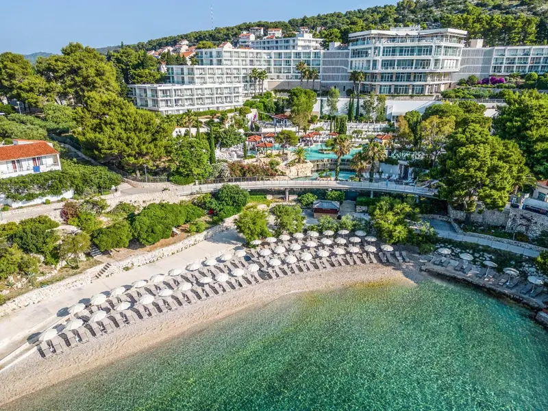 Vue aérienne d'un complexe hôtelier avec piscine et plage.