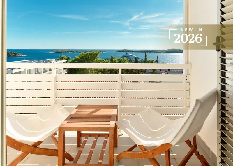 Terrasse avec mobilier en bois et vue sur la mer.