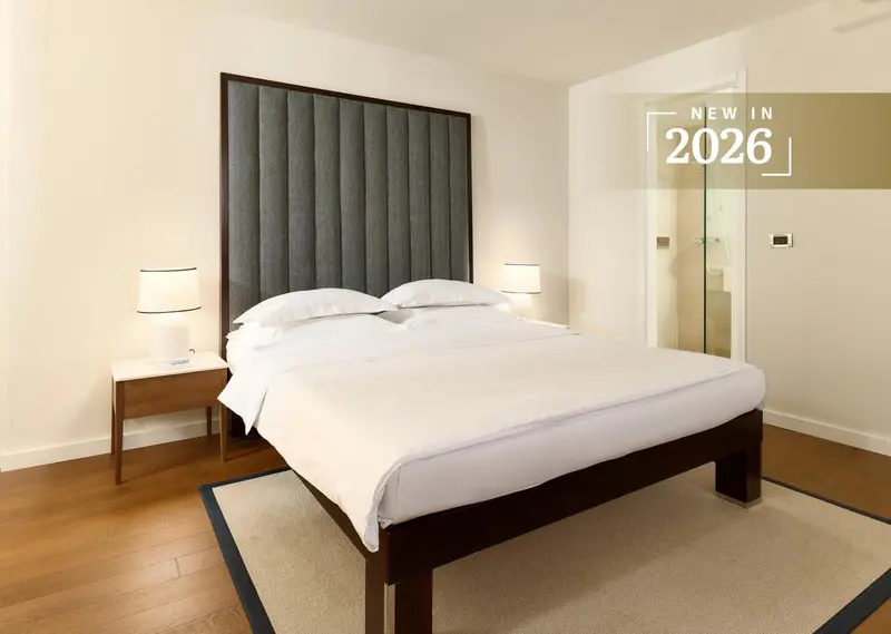 Une chambre lumineuse avec un grand lit recouvert de draps blancs.