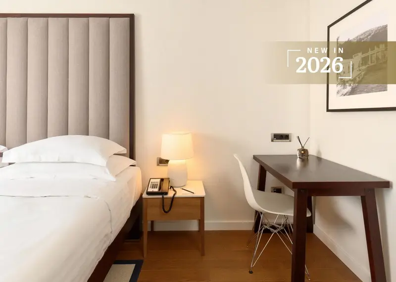 Une chambre lumineuse avec un grand lit et un bureau.