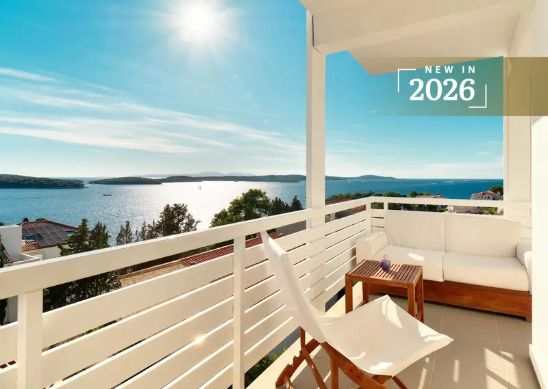 Vue dégagée sur la mer depuis une terrasse aménagée avec salon de jardin.