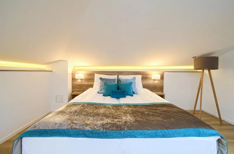 Un lit est fait dans une chambre lumineuse et moderne.