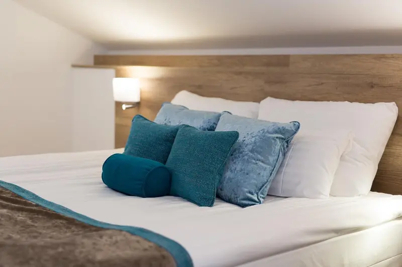 Un lit confortable avec des oreillers moelleux et une couverture décorative.