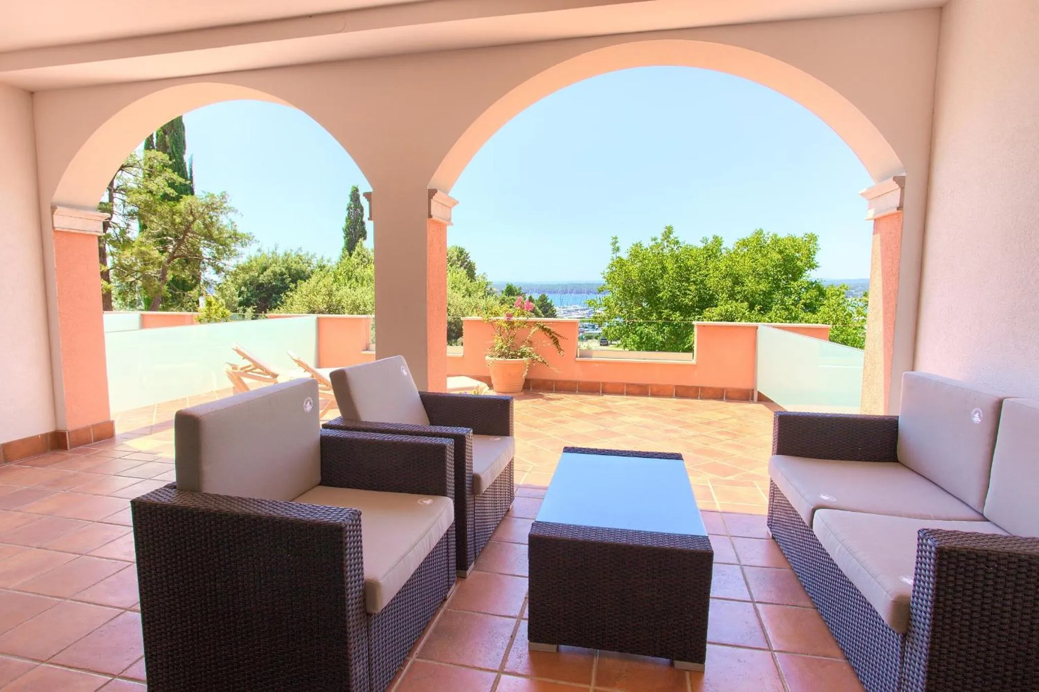 Espace de détente extérieur avec mobilier confortable et vue sur la mer.