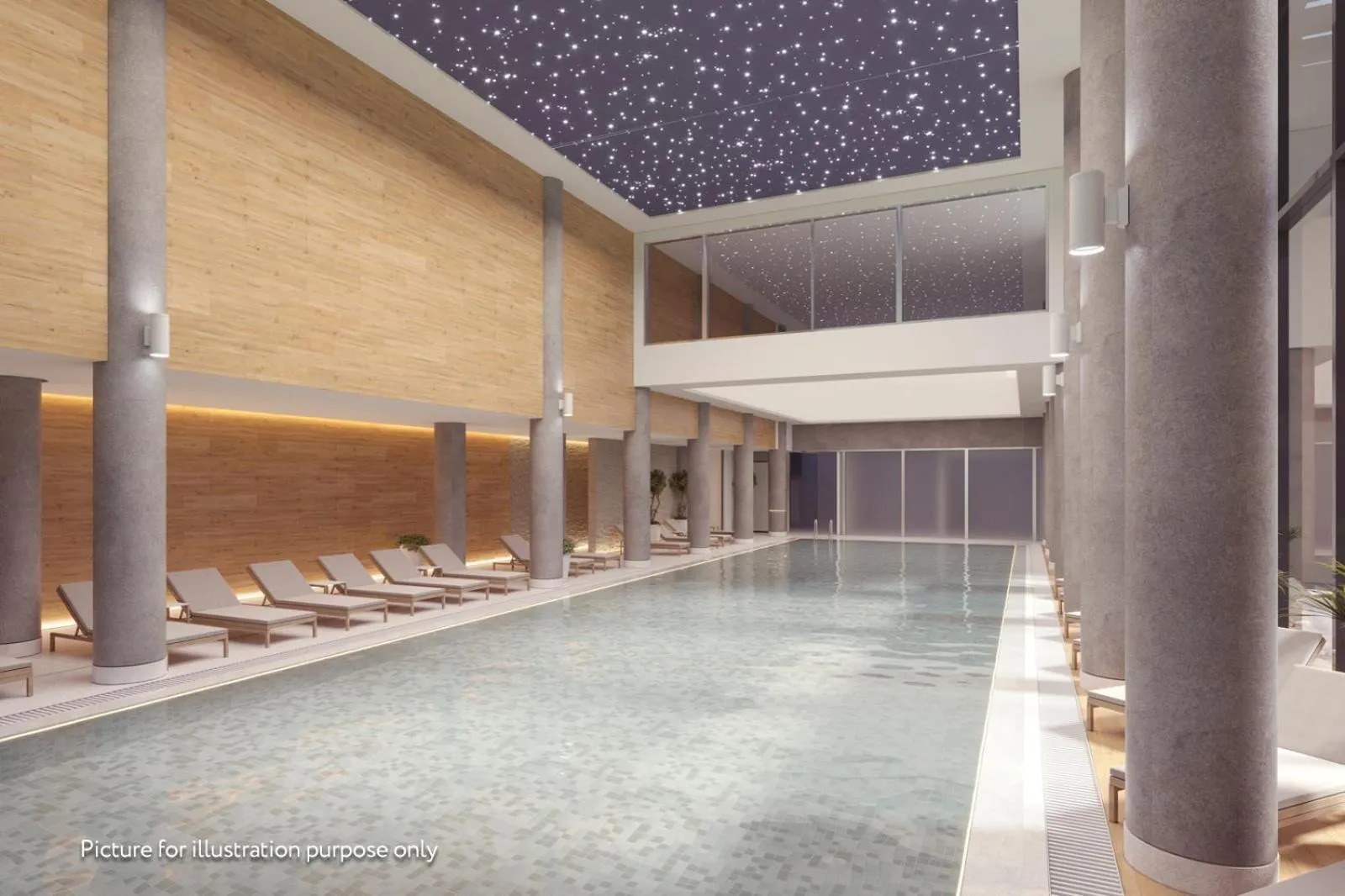 Une piscine intérieure lumineuse avec des transats alignés sur le bord.
