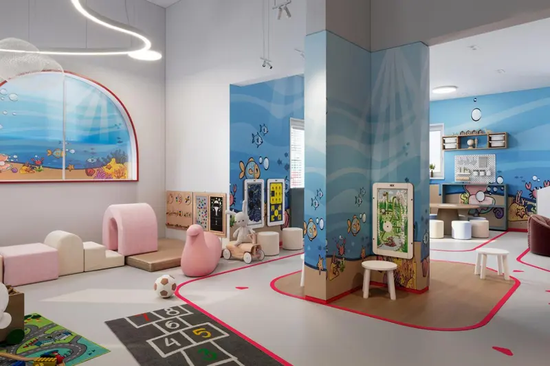 Espace de jeux lumineux avec des éléments décoratifs marins et des meubles colorés.