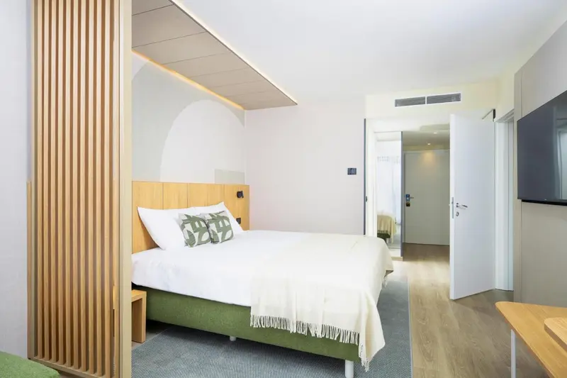 Une chambre lumineuse avec un lit double et une décoration moderne.
