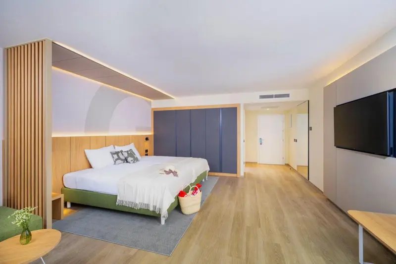 Une chambre lumineuse avec un grand lit et un décor moderne.