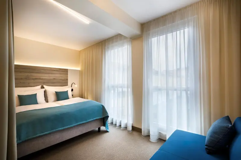 Une chambre lumineuse avec un grand lit et un coin salon.