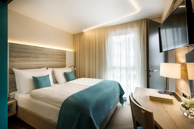 Une chambre lumineuse avec un grand lit et un bureau.