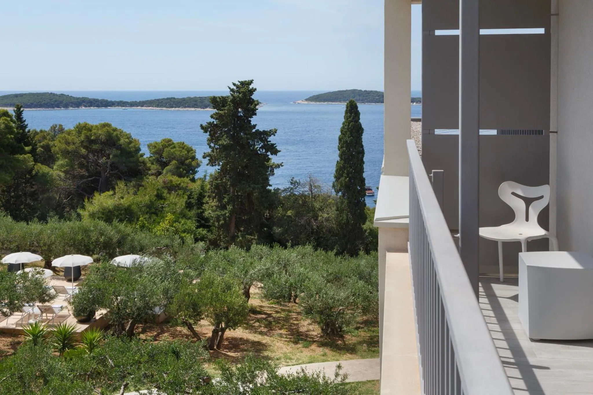 Terrasse avec mobilier design donnant sur une vue mer et une végétation luxuriante.