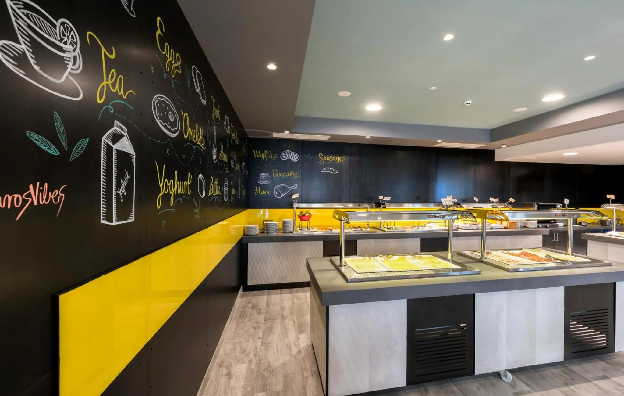Un buffet propose une variété de plats et de boissons dans une salle lumineuse.